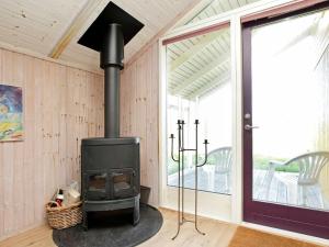 a wood stove in a room with a porch at 8 person holiday home in Oksb l in Vejers Strand