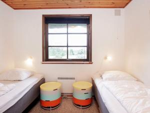 two twin beds in a room with a window at 6 person holiday home in Bl vand in Blåvand