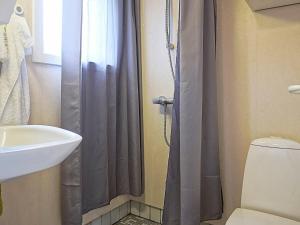 a bathroom with a shower curtain and a toilet at Holiday home Hasle III in Hasle