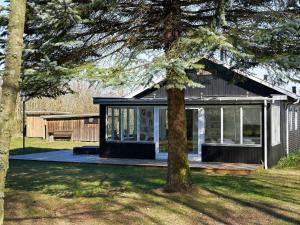 a black and white house with a tree at 6 person holiday home in Hasle-By Traum in Hasle +14 photos