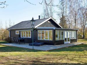 a small cabin with a deck in the grass at Holiday home Hasle III in Hasle