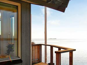 a house with a balcony with a view of the ocean at 2 person holiday home in TORSLANDA in Hällsvik