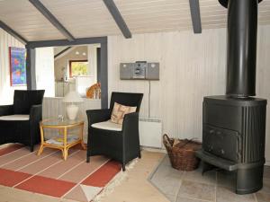 sala de estar con estufa de leña y sillas en 6 person holiday home in Vejers Strand en Vejers Strand