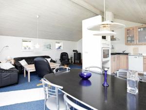 ブラーバンドにあるThree-Bedroom Holiday home in Blåvand 87のキッチン、リビングルーム(テーブル、椅子付)