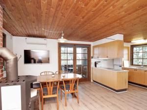 a kitchen with a wooden ceiling and a table and chairs at 6 person holiday home in Bl vand in Blåvand