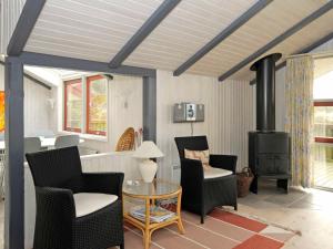 a living room with chairs and a wood stove at 6 person holiday home in Vejers Strand in Vejers Strand