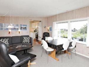 4 person holiday home in Vejers Strand في فايرس ستراند: غرفة معيشة وغرفة طعام مع طاولة وكراسي