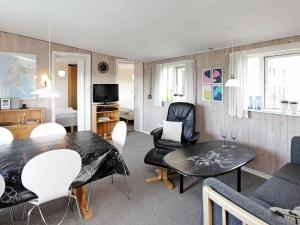 4 person holiday home in Vejers Strand في فايرس ستراند: غرفة معيشة مع طاولة طعام وكراسي