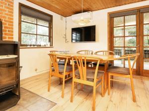 a dining room with a wooden table and chairs at 6 person holiday home in Bl vand in Blåvand