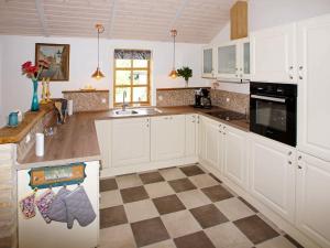 a kitchen with white cabinets and a checkered floor at 8 person holiday home in Hemmet in Hemmet