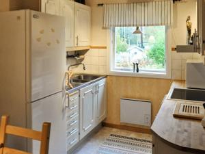 a kitchen with a refrigerator and a sink and a window at 5 person holiday home in KIL in Kil