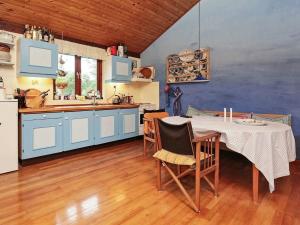 cocina con mesa y cocina con armarios azules en 6 person holiday home in Nyk bing Sj, en Nyrup