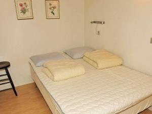 1 cama con 2 almohadas en una habitación en Holiday Home Fasanvej VI en Henne Strand