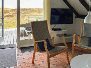 a living room with a chair and a television at 6 person holiday home in Ringk bing in Klegod