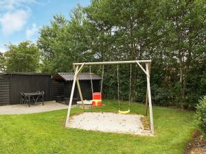 a swing set in a yard with a playground at 8 person holiday home in Tarm in Hemmet