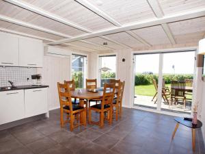 a kitchen and dining room with a table and chairs at Three-Bedroom Holiday home in Hemmet 89 in Falen