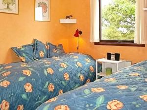 a bedroom with a bed with a blue comforter and a window at Two-Bedroom Holiday home in Lemvig 22 in Lemvig