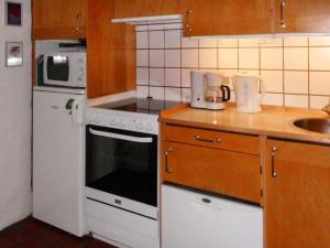 ブラーバンドにある6 person holiday home in Bl vandのキッチン(白いコンロ付) 洗面台の横にあるトップオーブン