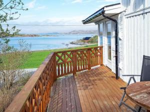 een houten terras met uitzicht op het water bij 11 person holiday home in kolvereid in Kolvereid