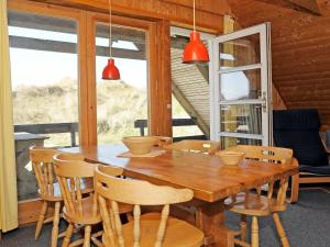 een eetkamer met een houten tafel en stoelen bij 6 person holiday home in Ringk bing in Klegod