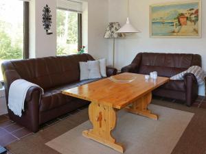 Oddeにある8 person holiday home in Hadsundのリビングルーム(ソファ、木製テーブル付)