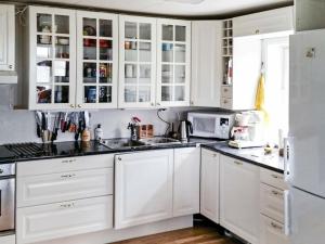 a white kitchen with white cabinets and a sink at 11 person holiday home in kolvereid in Kolvereid
