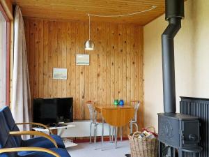 a living room with a stove and a table with chairs at 8 person holiday home in Harbo re in Harboør