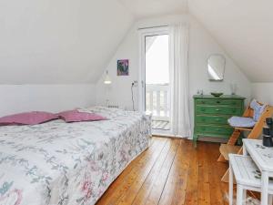 a bedroom with a bed and a dresser and a window at Three-Bedroom Holiday home in Harboøre 24 in Harboør