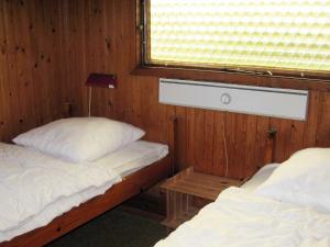 2 camas individuales en una habitación con ventana en Two-Bedroom Holiday home in Løkken 25 en Grønhøj