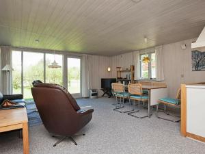 a living room with a chair and a table and chairs at 8 person holiday home in Hurup Thy in Sindrup