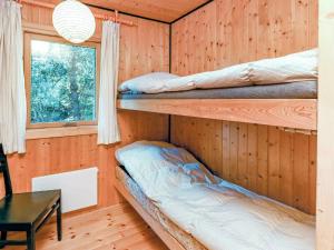 ブロックフスにあるThree-Bedroom Holiday home in Blokhus 21の木造キャビン内のベッドルーム1室(二段ベッド2組付)