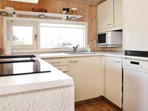 ブロックフスにある6 person holiday home in Blokhusの白いキャビネットとシンク付きのキッチン