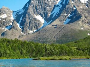 a mountain range with a body of water and trees at 6 person holiday home in Nord Lenangen in Sørlenangen