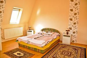 sypialnia z łóżkiem, oknem i dywanem w obiekcie Kastely Panzio II. w Hajduszoboszlo