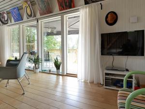a living room with a television and a sliding glass door at 5 person holiday home in RYSSBY in Ryssby