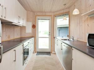 Fjand Gårdeにある8 person holiday home in Ulfborgの白いキャビネットと大きな窓付きのキッチン