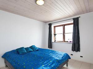 1 dormitorio con cama con sábanas azules y ventana en 8 person holiday home in Harpelunde, en Harpelunde
