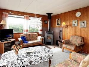uma sala de estar com uma mesa e uma lareira em Two-Bedroom Holiday home in Løkken 25 em Grønhøj