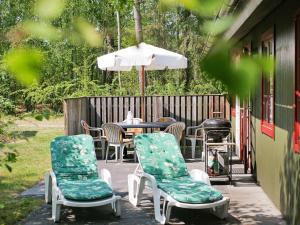 a patio with two chairs and a table and an umbrella at 6 person holiday home in Nex in Snogebæk