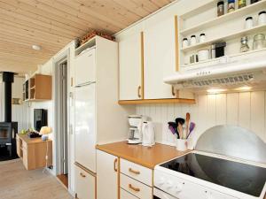 Strandbyにある6 person holiday home in Strandbyのキッチン(白いキャビネット、白い冷蔵庫付)