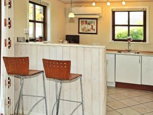 a kitchen with two bar stools and a counter at 8 person holiday home in N rre Nebel in Nørre Nebel