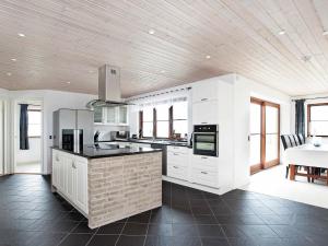 una cocina con armarios blancos y encimeras negras en 8 person holiday home in Harpelunde, en Harpelunde