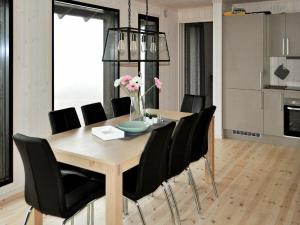 een eetkamer met een houten tafel en zwarte stoelen bij 10 person holiday home in yer in Øyer