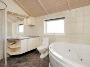 a bathroom with a tub and a toilet and a sink at 6 person holiday home in Harbo re in Harboør