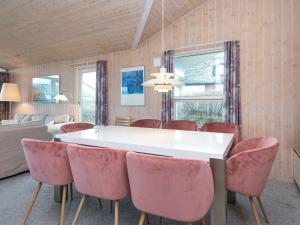 ヘンネ・ストランドにある6 person holiday home in Henneのダイニングルーム(ピンクの椅子、白いテーブル付)