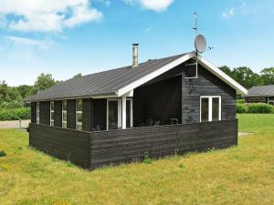 una pequeña casa con techo en un campo de césped en 6 person holiday home in Hals en Hals