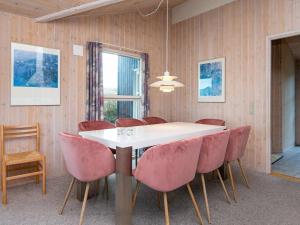 ヘンネ・ストランドにある6 person holiday home in Henneのダイニングルーム(白いテーブル、ピンクの椅子付)