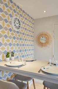 une salle à manger avec une table, des chaises et une horloge murale dans l'établissement LocationsTourcoing - Le Famelart, à Tourcoing