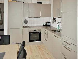 a kitchen with white cabinets and a sink and a table at 10 person holiday home in yer in Øyer