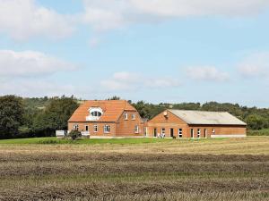 una gran casa de ladrillo junto a un campo en 14 person holiday home in Fur en Fur